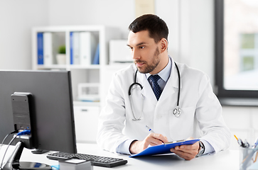 Image showing doctor with clipboard and computer at hospital