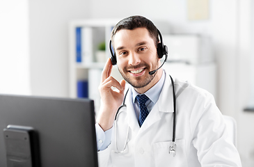 Image showing happy doctor with computer and headset at hospital
