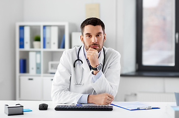 Image showing thinking male doctor with stethoscope at hospital