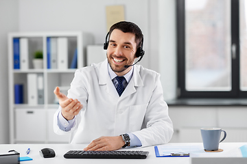 Image showing male doctor in headset having video call at clinic