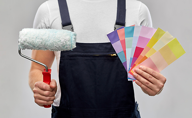 Image showing close up of painter with roller and color charts