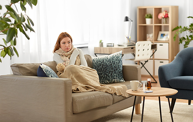 Image showing sad sick woman in blanket and scarf at home