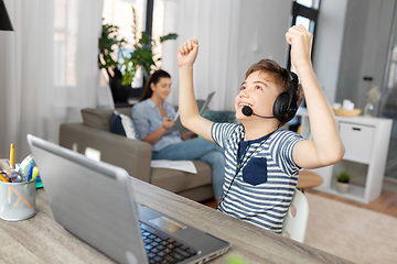 Image showing boy with laptop and headphones at home