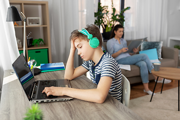 Image showing sad boy with laptop and headphones at home