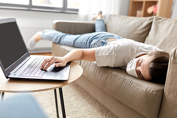 Image showing sick bored woman with laptop lying on sofa at home