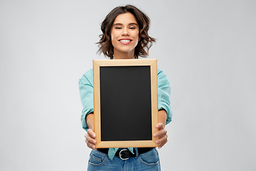 Image showing portrait of smiling woman showing black chalkboard