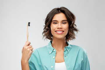 Image showing smiling young woman with wooden toothbrush