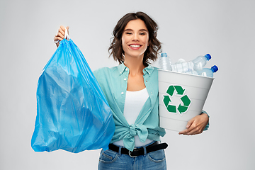 Image showing smiling woman sorting plastic waste and trash bag