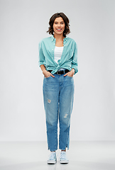 Image showing smiling young woman in turquoise shirt and jeans