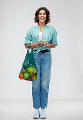 Image showing woman with bag for food shopping and glass bottle