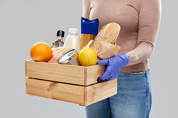 Image showing woman in gloves with food in wooden box