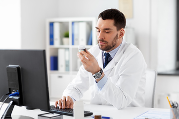 Image showing male doctor with medicine and computer at hospital