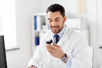 Image showing smiling male doctor with medicine at hospital