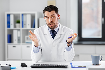 Image showing doctor in earphones having video call at clinic