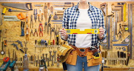 Image showing woman builder with level and working tools on belt