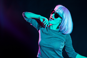 Image showing happy woman in pink wig and sunglasses dancing