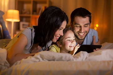 Image showing family with tablet pc in bed at night at home