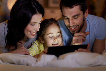 Image showing family with tablet pc in bed at night at home