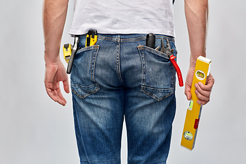 Image showing man with level and working tools in pockets