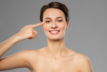 Image showing beautiful young woman pointing to her eye