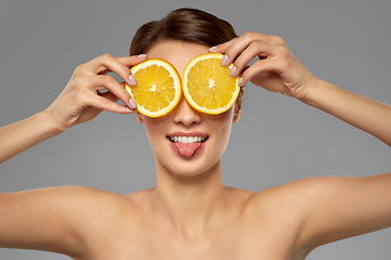 Image showing beautiful woman making eye mask of orange slices