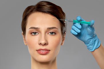 Image showing beautiful young woman and hand with syringe