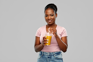 Image showing happy african american woman drinking orange juice