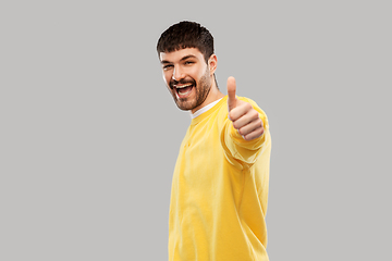 Image showing smiling young man showing thumbs up