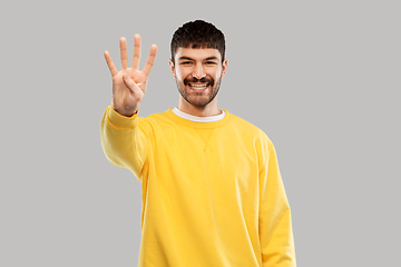 Image showing man in yellow sweatshirt showing three fingers