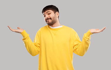 Image showing confused man in yellow sweatshirt shrugging