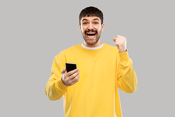 Image showing happy smiling young man with smartphone