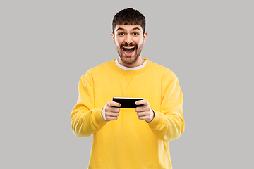 Image showing happy laughing young man with smartphone