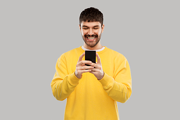 Image showing happy smiling young man with smartphone