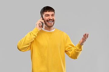 Image showing happy smiling young man calling on smartphone