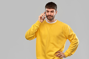 Image showing puzzled young man calling on smartphone