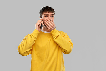 Image showing shocked young man calling on smartphone