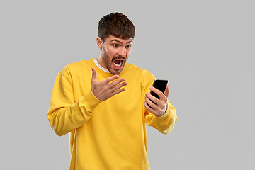 Image showing angry young man with smartphone