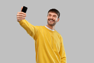 Image showing smiling young man taking selfie with smartphone