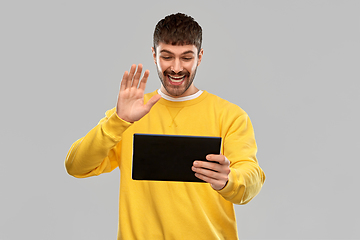 Image showing smiling young man with tablet pc having video call