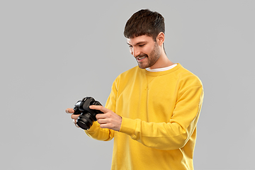 Image showing smiling young man with digital camera