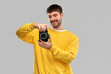 Image showing smiling young man with digital camera