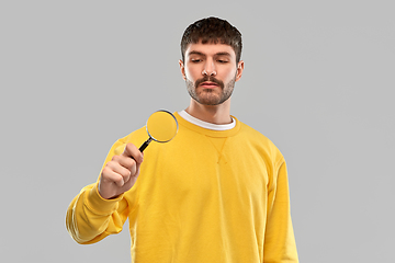 Image showing man in yellow sweatshirt with magnifier