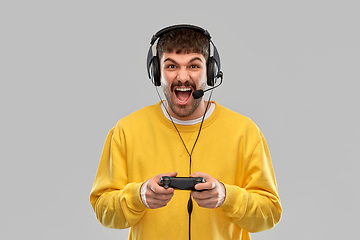 Image showing man with headset and gamepad playing video game