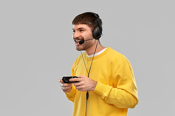 Image showing man with headset and gamepad playing video game