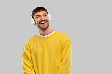 Image showing happy young man in headphones listening to music