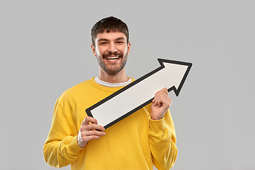 Image showing smiling man holding big arrow pointing to right