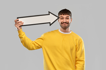 Image showing smiling man holding big arrow pointing to his head