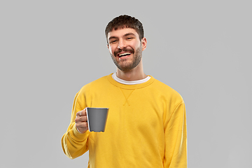 Image showing happy smiling young man with coffee cup