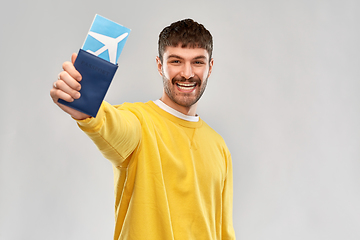 Image showing smiling young man with air ticket and passport