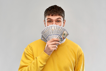 Image showing happy young man in yellow sweatshirt with money